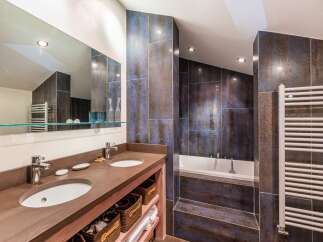 Step into luxury with this stunning bathroom featuring a sleek double vanity and a relaxing soaking tub.