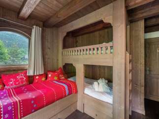 Step into this charming bedroom featuring a cozy bunk bed and a comfortable daybed, perfect for a family getaway.