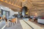 Experience luxury living in this stunning chalet, featuring a modern kitchen and a cozy living area with a fireplace.