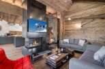 Experience luxury living in this stunning chalet, featuring a modern fireplace and a cozy living area.