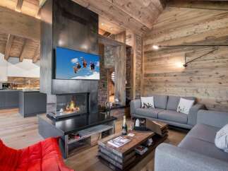 Experience luxury living in this stunning chalet, featuring a modern fireplace and a cozy living area.