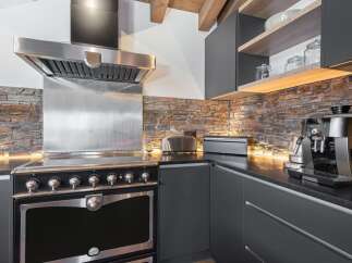 Discover the epitome of culinary luxury in this stunning kitchen! Featuring a high-end range, stainless steel hood, and sleek countertops, this space is designed for both style and functionality.