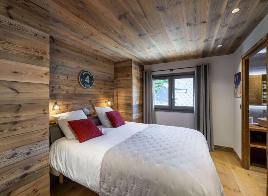 This cozy bedroom features stunning wood paneling on the walls and ceiling, creating a warm and inviting atmosphere.