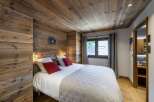 This cozy bedroom features stunning wood paneling on the walls and ceiling, creating a warm and inviting atmosphere.
