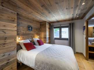 This cozy bedroom features stunning wood paneling on the walls and ceiling, creating a warm and inviting atmosphere.