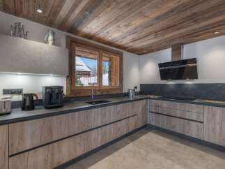 This stunning kitchen boasts a rustic charm with its wooden ceiling and cabinetry, creating a warm and inviting atmosphere.