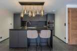 This modern kitchen boasts sleek, dark cabinetry and a stylish island with seating, perfect for entertaining.