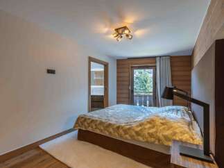 Experience the epitome of comfort in this stunning bedroom, featuring a cozy bed and a stylish lamp.