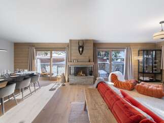 Experience luxury living in this stunning chalet, featuring a cozy fireplace and expansive windows that frame breathtaking mountain views.