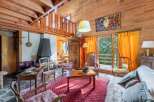 Discover the charm of this cozy chalet-style living room, featuring a stunning wooden interior and a welcoming fireplace.
