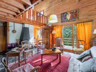 Discover the charm of this cozy chalet-style living room, featuring a stunning wooden interior and a welcoming fireplace.