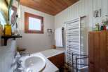 This charming bathroom features a classic design with a wooden ceiling and a window that allows natural light to flood the space.