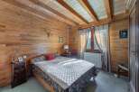 This charming bedroom boasts a warm, inviting ambiance with its wood-paneled walls and ceiling.