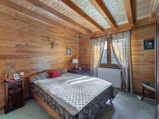 This charming bedroom boasts a warm, inviting ambiance with its wood-paneled walls and ceiling.