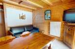 This charming property features a cozy living space with a rustic wooden interior, perfect for a relaxing getaway.
