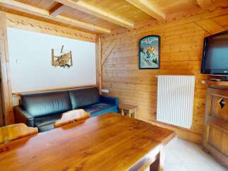 This charming property features a cozy living space with a rustic wooden interior, perfect for a relaxing getaway.