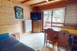 This charming chalet-style living space features warm wooden paneling and a cozy atmosphere.