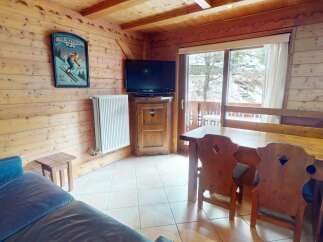 This charming chalet-style living space features warm wooden paneling and a cozy atmosphere.