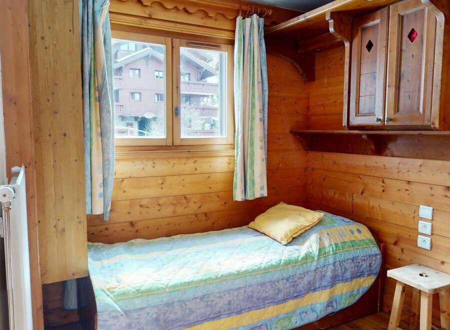 Cozy and charming bedroom featuring a wooden interior, creating a warm and inviting atmosphere.