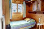 Cozy and charming bedroom featuring a wooden interior, creating a warm and inviting atmosphere.