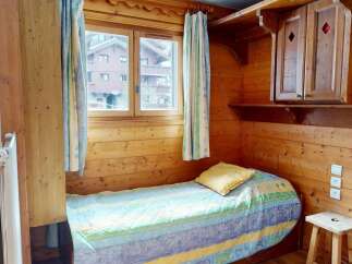 Cozy and charming bedroom featuring a wooden interior, creating a warm and inviting atmosphere.