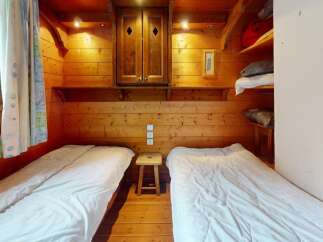 Cozy cabin bedroom featuring two twin beds, perfect for a comfortable stay.