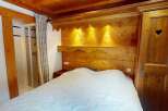 Discover the charm of this cozy bedroom featuring a rustic wooden headboard and a comfortable bed.