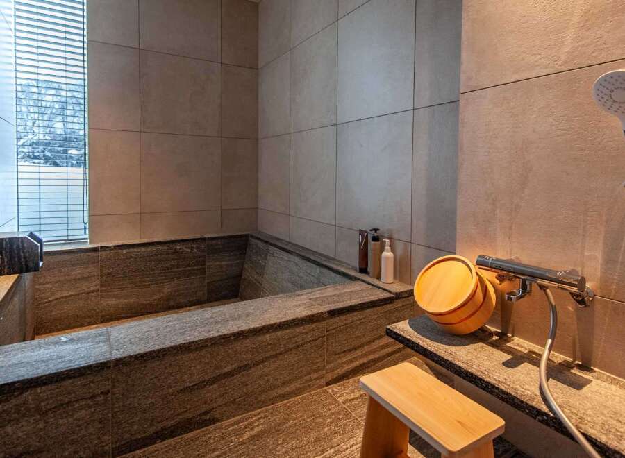 Experience tranquility in this luxurious bathroom featuring a stunning stone bathtub.