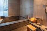 Experience tranquility in this luxurious bathroom featuring a stunning stone bathtub.
