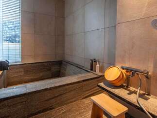 Experience tranquility in this luxurious bathroom featuring a stunning stone bathtub.