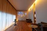 Experience luxury living in this stunning property featuring a cozy living room with a projector screen displaying a winter scene.