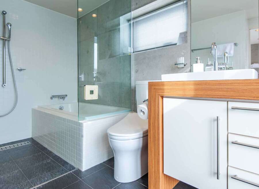 Step into luxury with this modern bathroom, featuring a sleek glass-enclosed shower and a relaxing bathtub.