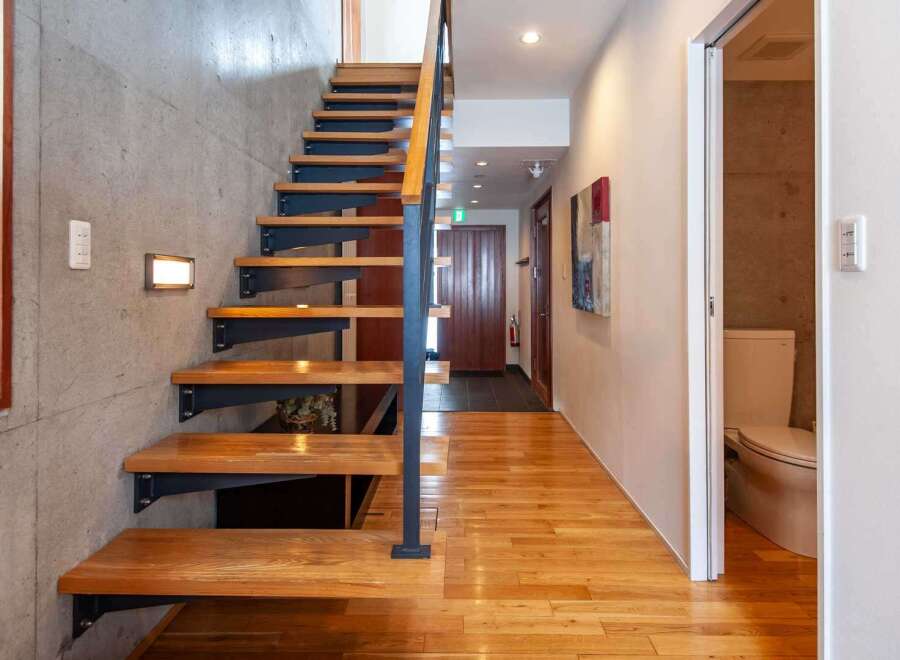 Discover modern living in this stunning property featuring a beautifully designed staircase with wooden steps and a sleek metal railing.