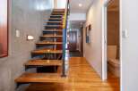 Discover modern living in this stunning property featuring a beautifully designed staircase with wooden steps and a sleek metal railing.