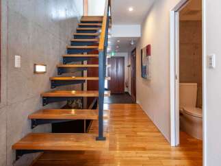 Discover modern living in this stunning property featuring a beautifully designed staircase with wooden steps and a sleek metal railing.