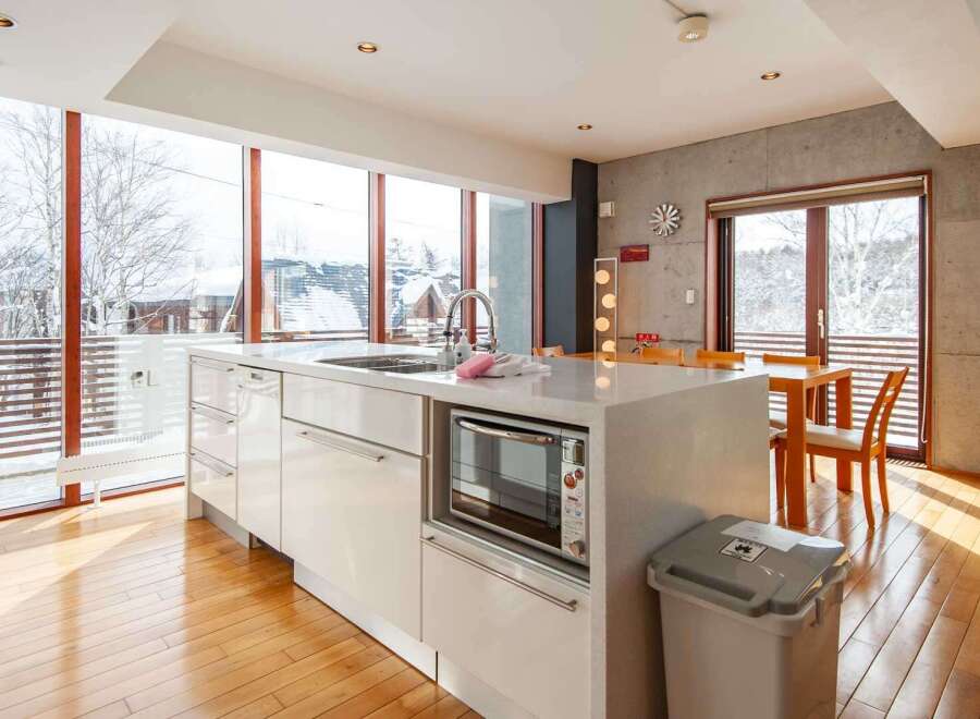 Experience the epitome of modern living in this stunning kitchen, boasting expansive windows that frame breathtaking snowy landscapes.
