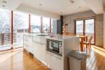 Experience the epitome of modern living in this stunning kitchen, boasting expansive windows that frame breathtaking snowy landscapes.