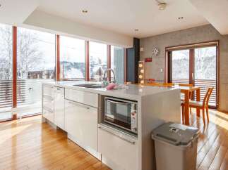 Experience the epitome of modern living in this stunning kitchen, boasting expansive windows that frame breathtaking snowy landscapes.