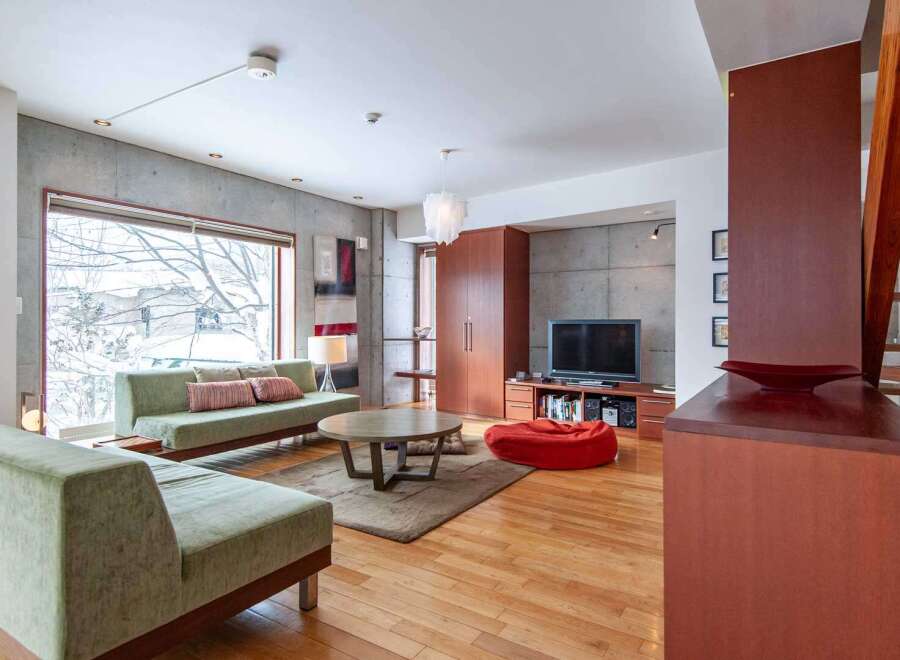This modern living space boasts a sleek design with concrete walls and hardwood floors.