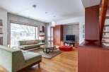 This modern living space boasts a sleek design with concrete walls and hardwood floors.