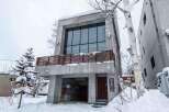 This modern concrete building offers a unique architectural design with a spacious interior and large windows.