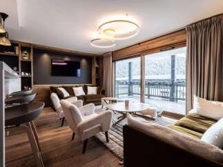 Experience luxury living in this stunning property, featuring a cozy living room with a fireplace and a modern kitchen.