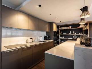 This modern kitchen boasts sleek cabinetry and a spacious island, perfect for culinary enthusiasts.