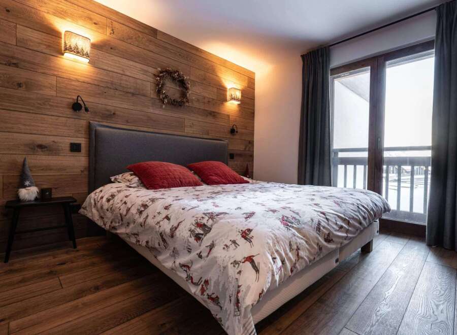 Experience the cozy charm of this bedroom, featuring a stunning wood-paneled wall that adds warmth and character.