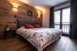 Experience the cozy charm of this bedroom, featuring a stunning wood-paneled wall that adds warmth and character.