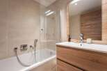This modern bathroom features a sleek design with a glass shower enclosure and a stylish wooden vanity.