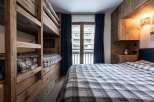 This cozy bedroom features custom-built wooden bunk beds, perfect for accommodating guests or family.