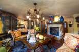 Step into luxury with this stunning living room, featuring a unique antler chandelier and a cozy fireplace.