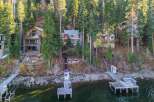 Discover your dream lakeside retreat! This stunning property boasts multiple homes nestled amongst towering trees, offering unparalleled privacy and breathtaking views.
