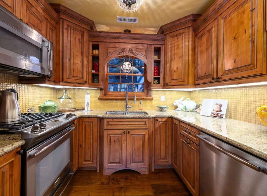 Step into a beautifully designed kitchen featuring custom wooden cabinetry and elegant granite countertops.